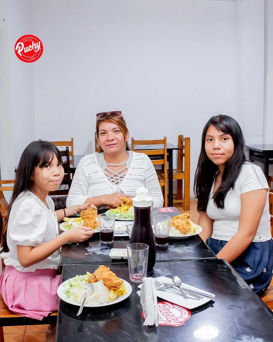 Una mamá y sus hijas comiendo en Puchy