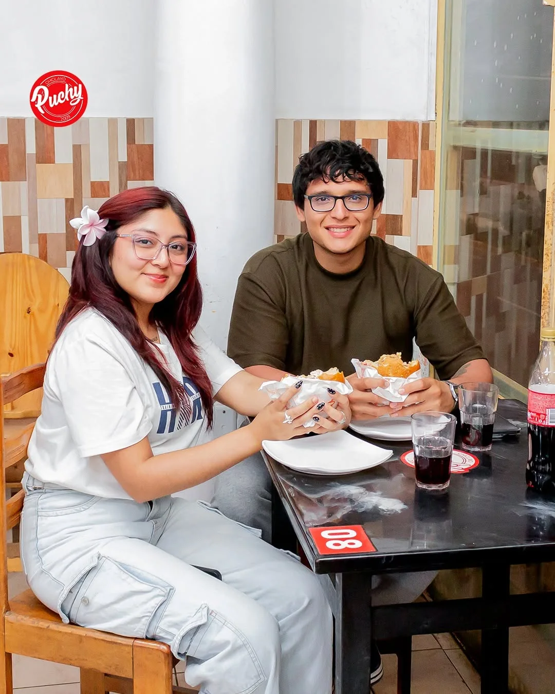 Una pareja con sus hamburguesas en Puchy